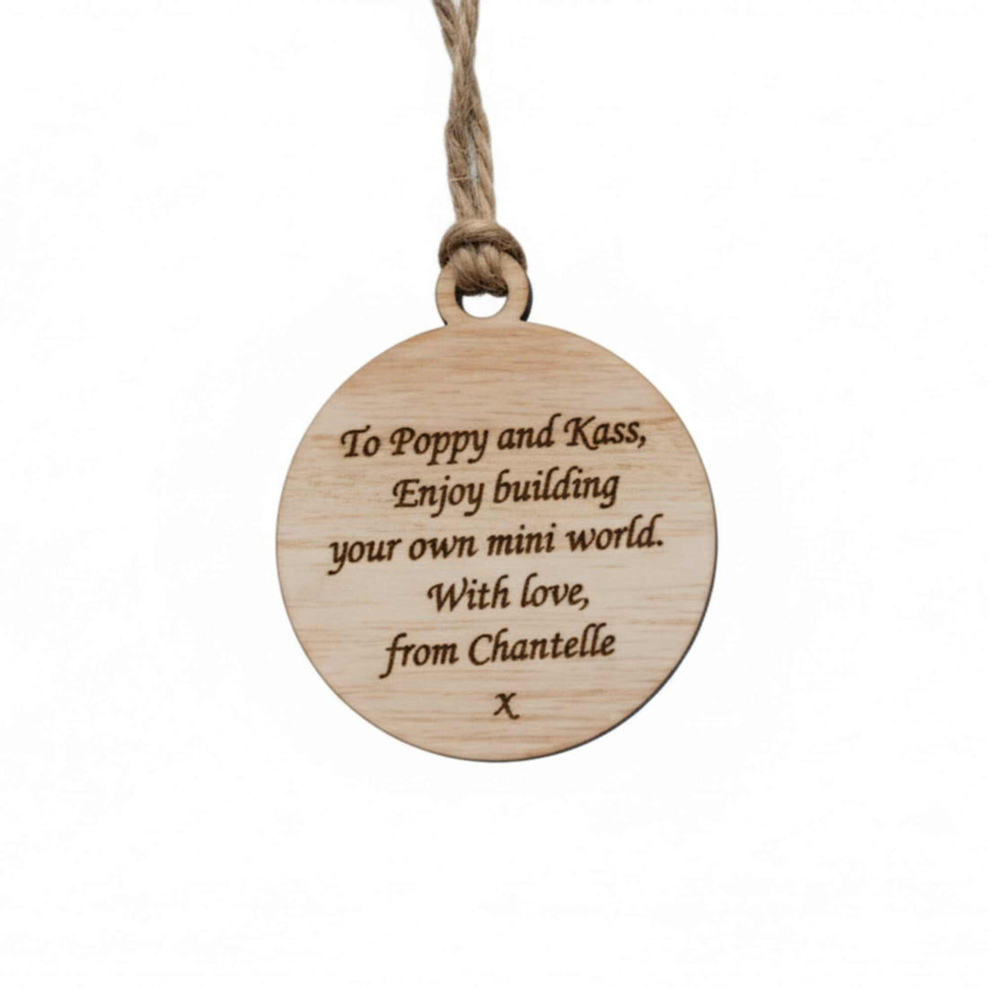 Wooden pendant with engraved text on a white background